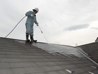 ターボノズルで屋根を高圧洗浄する職人