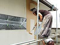 足場に上って外壁を塗装する職人