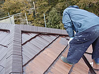 瓦屋根を塗装している職人