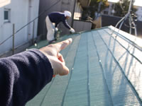 コロニアル屋根を塗っている職人