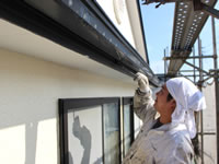 破風板を塗装する職人