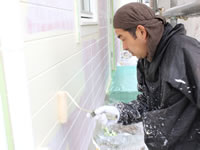 下地の赤が浮いてこないように工夫して塗装する職人